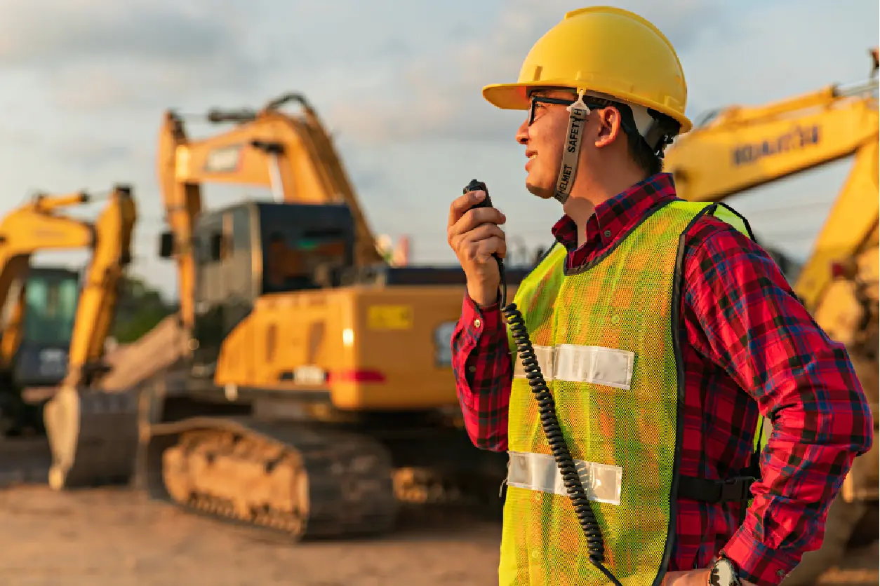 New Project(17) Construction worker with radio near excavators.